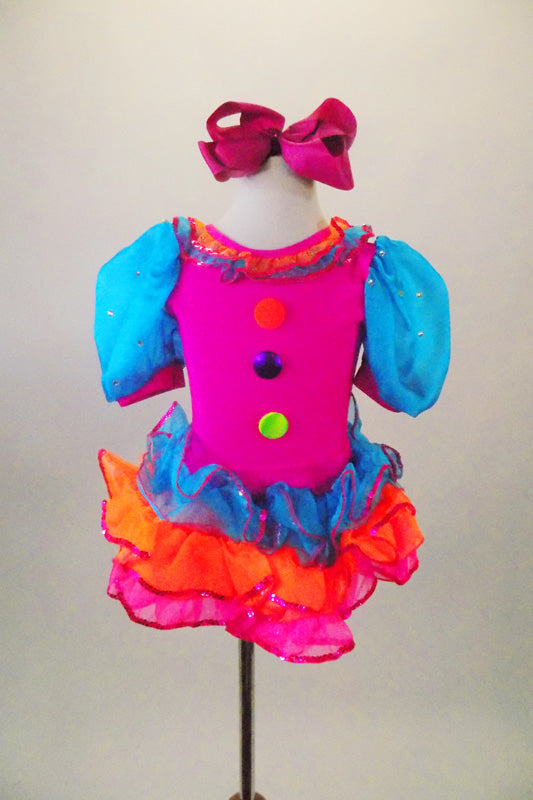 Bright pink clown themed leotard dress has turquoise pouf sleeves, neck ruffles & buttons. Skirt is layers of turquoise orange & pink sequined ruffles. Comes with hair bow. Front