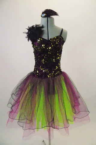 Magenta purple based dress has black lace overlay with lime green sequins & feather accent at right shoulder. The tulle skirt is layers of lime magenta & black. Comes with matching feather hair accessory. Front