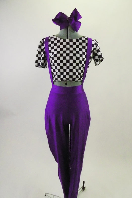 Black and white checkered short sleeve half-top is accompanied by purple leggings with suspenders. Comes with large bow accessory. Front