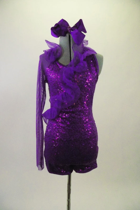 Purple sequined lace short unitard has a halter neck & curly ruffled organza cascading down the front. Right sleeve is full length purple stretch mesh. Comes with matching hair accessory. Front