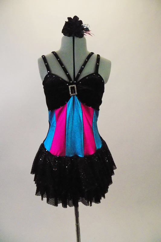 Black velvet leotard has layered sequined skirt. Bust has double straps lined with crystals & large crystal brooch. Has pink & turquoise vertical striped torso. Comes with floral hair accessory. Front