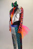 3-piece wild, bright costume with silver leggings & jacket has bright bold patterned inlays on legs, arms & lapels. Legging has pink-orange tutu bustle skirt. Comes with bright orange neck tie & green hair bow. Left side