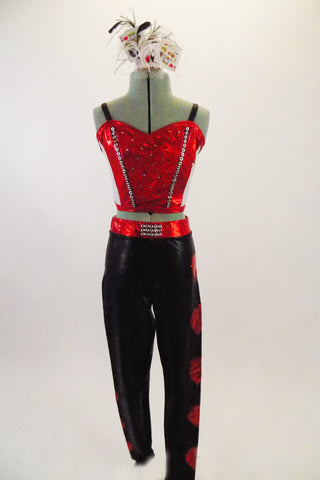 Two-piece card themed costume has red & white camisole half top with jewel & crystal accents at front. The black leggings have red hearts on leg & jewel buckle. Comes with card and feather hair accessory. Front