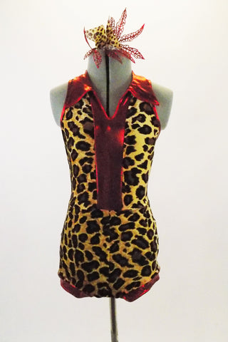 Leopard print halter leotard has V-neck front and keyhole back. The edging and center front are bright red metallic. Comes with matching hair accessory. Front