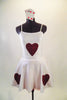 Card themed costume is a white camisole 2-piece dress has skirt with layers of red tricot underlay. There are sequined red hearts on the skirt and torso. Comes with 4-suit card hair accessory. Front