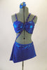 Iridescent blue metallic 2-piece costume has bra and angled skirt with attached panty & crystalled elastic straps crossing from right hip over torso & back. Comes with hair accessory. Front