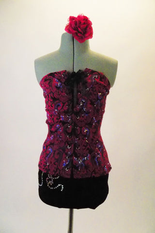 2-piece costume has pretty fuchsia and black brocade corset top with purple and crystal accents and ribbon lacing. The matching black velvet shorts have a swirled crystal accent design. Comes with matching floral hair accessory. Front