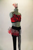 Funky 2-piece costume has a red sequined half top with front lacing & black and white striped piping & straps. The leggings are half black & half black-white vertical striped. Leggings have a red & black-white dotted hip ruffle on the right hip. Comes with matching ruffled hair accessory. Side