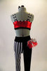 Funky 2-piece costume has a red sequined half top with front lacing & black and white striped piping & straps. The leggings are half black & half black-white vertical striped. Leggings have a red & black-white dotted hip ruffle on the right hip. Comes with matching ruffled hair accessory. Back