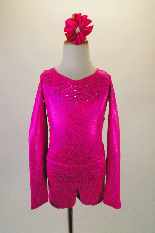 Long sleeved hot pink metallic marbled short unitard has crystalled front and back accents. The open back has a fully crystalled bow that rests at the base of the lower back. Comes with a hair accessory. Front