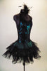 Teal based leotard dress has black laced, overlay bodice with pinch front. The halter collar has wide back straps emerging from the back collar. The layered ruffle black tulle skirt gives the costume volume and a balletic touch. Comes with matching black feather hair accessory. Side