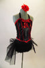 Back halter corset with red piping and a front bow is accompanied by black fully fringed shorts with black tulle bustle with a large red back bow. Comes with red and black floral hair accessory. Side