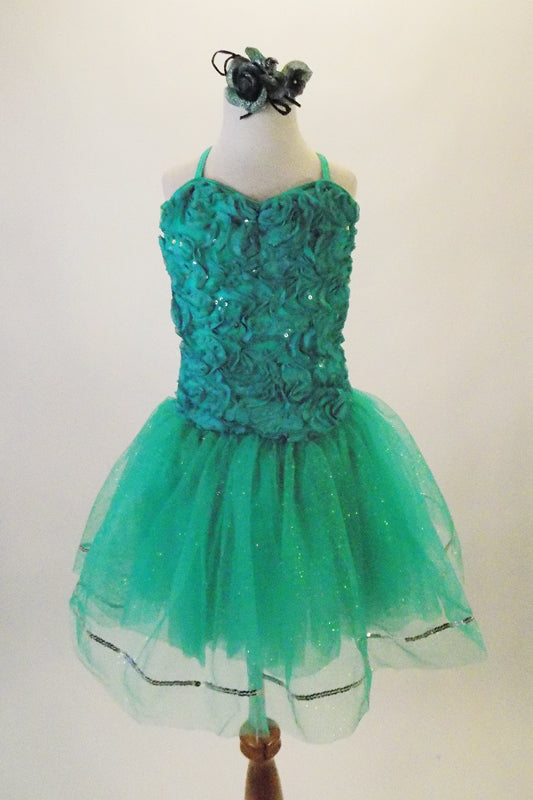 Delicate turquoise-sea green dress has chiffon ribbon rose lace front with a plain back and criss-cross straps.  The full crystal tulle skirt in shades of blue-green has silver sequin edge. Comes with crystal barrette hair accessory. Front