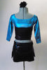 Turquoise and silver ¾ sleeve marbled half-top has attached black leatherette corset lace-up belt. The matching bottom is a black leatherette skirt with lacing accents at the hips and attached turquoise briefs. Comes with a hair accessory. Front