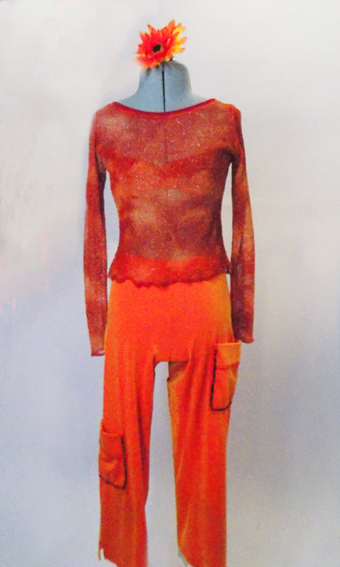 This two-piece is bright orange textured capri pants with gold undertone has large red-sequined pockets on left hip and right thigh. The matching long sleeved top is a large mesh net in marbled shades of orange and red with scattered gold fleck throughout. Comes with red bra and hair accessory. Front