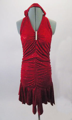 Red sparkle stretch halter neck, open-backed dress, is gathered along the front and back vertically to create a shapely silhouette. The skirt falls below the gathers for a feminine look.  A long crystal brooch highlights the gathered bust area.  Comes with matching floral headband accessory. Front