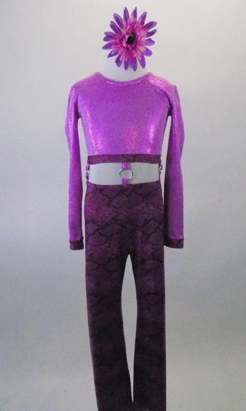 Purple unitard is actually two parts joined at the waist by a series of looped rings. The glitter dot scoop-neck half top has long sleeves and a fully lace-up back. The pants are a snake-skin print in shades of pinks and purples. Comes with a hair accessory. Front