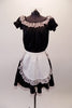 Three-piece maid or waitress costume had black pouffe sleeved blouse with lace trim. The matching black pull-on skirt has lace trim and an attached large white lace edged apron. Comes with separate black bottom and bow hair accessory. Front