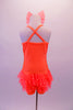 Cheery bright orange sequined short unitard shows well on stage. It has sheer polka dot ruffle skirt and cross back straps. Comes with matching bow hair accessory. Back