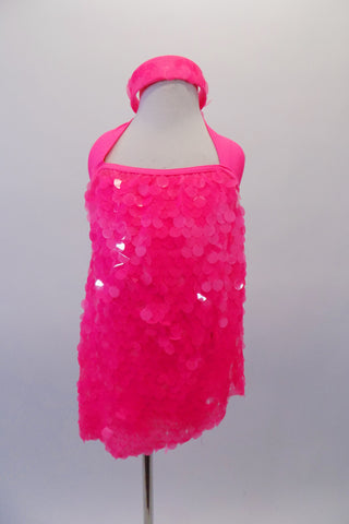 Bright neon pink halter dress is comprised entirely of large circle dangle sequins. This costume has a vertical band at the back center and nude shoulder straps. Comes with matching headband accessory. Front