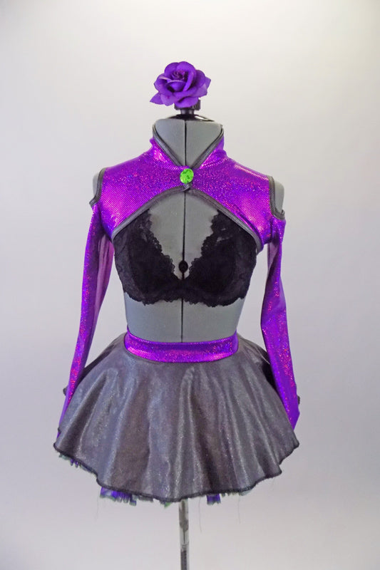 three-piece costume has a black lace bra base (30A) with purple sparkle, long sleeved, cold shoulder shrug with neon green button accent. The accompanying skirt is a concrete grey overlay on top of purple & green tulle & matching waistband with large green bow at the back. Comes with floral hair accessory. Front