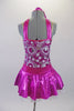 Sweet two-piece costume has white circular sparkle pattern on the bodice of a metallic pink base. The hater neck straps originate from a ring at the front of the bodice. The accompanying pull-on skirt is metallic pink with white tulle for volume. Comes with a purple floral hair accessory. Back