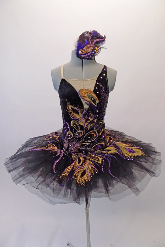 Peacock themed ballet tutu has a black base with beautiful gold & purple embroidered lace designs on the bodice & sheer overlay. The nude straps cross over at the back for good support. The accompanying black pull-on tutu & black briefs create the stunning base. Comes with a large matching hair accessory. Front