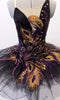 Peacock themed ballet tutu has a black base with beautiful gold & purple embroidered lace designs on the bodice & sheer overlay. The nude straps cross over at the back for good support. The accompanying black pull-on tutu & black briefs create the stunning base. Comes with a large matching hair accessory. Front zoomed