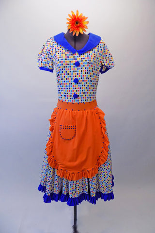 50s housewife themed, pouffe sleeved dress is a white base with colourful squares of blues, yellow & orange. The blue theme is repeated in the collar, sleeve cuffs, buttons & ruffled skirt hem. The orange attached apron compliments the square pattern in the dress with blue crystal accents. Comes with a hair accessory. Front