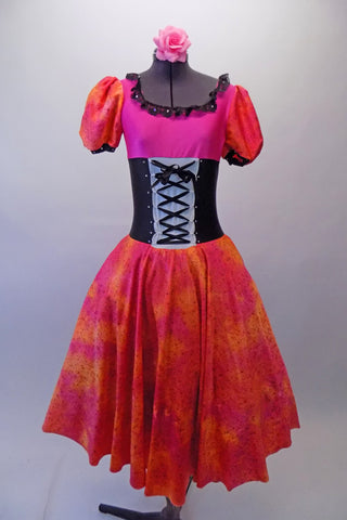 Theatrical dress is both peasant and royalty all at once. The layers of petticoat and pink bustle with a bow, create loads of volume beneath a colourful skirt in shades of red pink & orange. The skirt portion of the dress compliments the pink bodice, ruffled neckline, pouffe sleeves and faux corset laced waistband. Comes with Pink rose hair clip. Front