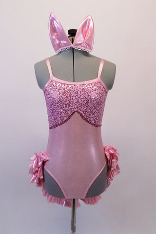 Pale pink sparkle leotard with a sequined bust area has a triple layered, ruffled and sequined open front, bustle skirt. Comes with matching pink piggy ears. Front