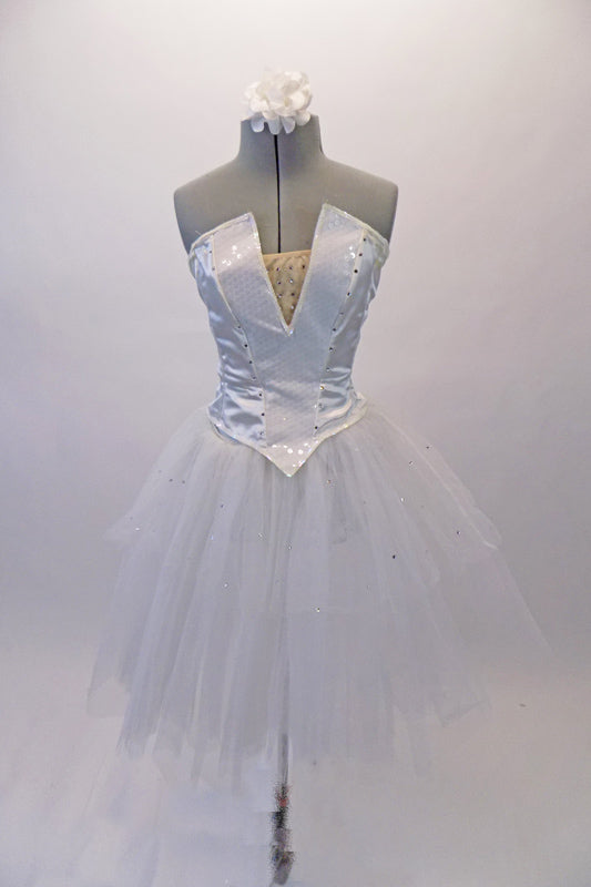 White crystalled ballet bodice has a sequined princess cut center with peaked font & nude sequined insert. There is a zipper closure at back. The white sheer overlay has scattered crystals like droplets of ice that sits over a white romantic pull-on tutu skirt. Comes with white floral hair accessory & removable straps. Front