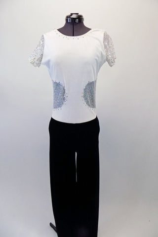 Black and white full unitard has boot-leg cut black velvet pant attached to a white velvet top. The top has sequined mesh inlay along the sleeves and center back that extends to the front at the waist. Crystals line the front of the neckline and sequined waist inlay. Front