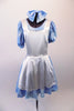 Pale blue floral dress with a faint white floral pattern has pouffe sleeves and an attached white pinafore apron with crystal accents. The tulle petticoat gives the knee length dress added volume. Comes with matching large bow hair accessory. Front