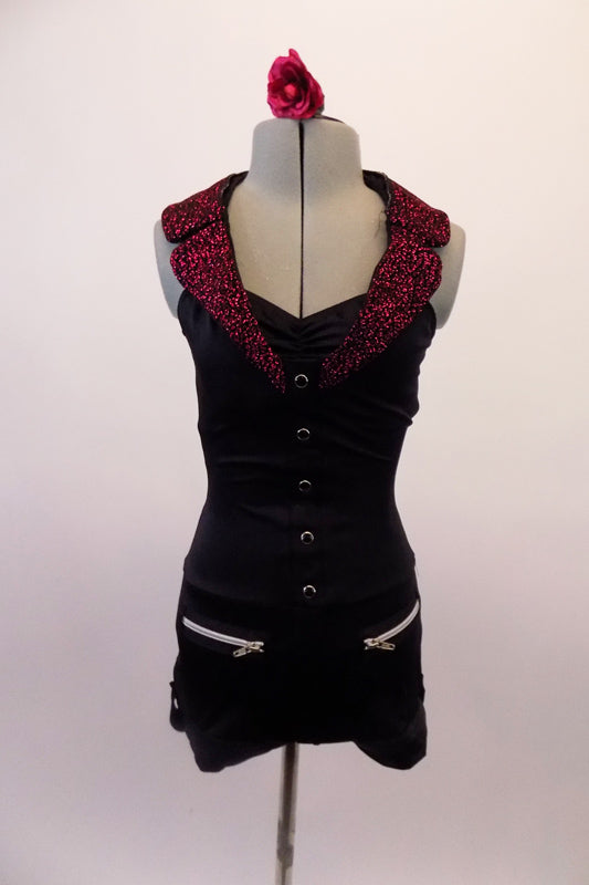 Biker themed short unitard has a fuchsia glitter lapel halter collar that attaches at the center of the bustline below the gathers. The fitted, open-backed torso is decorated with black and silver buttons along the front, that compliment the faux zipper pockets at the front of the shorts. Front