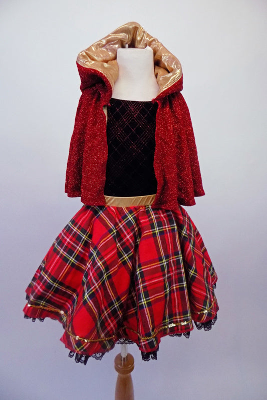 Black velvet leotard has a red glittery tartan pattern in the fabric. The accompanying red tartan skirt has gold waistband and sequin accent with black lace trim and tricot black petticoat. The finishing piece is a removable, gold lined, sparkly red hooded cape. Front