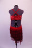 Sassy red salsa dress has red sequined right bust inlaid over nude mesh. The left side and asymmetrical skirt are comprised of layers of red fringe. The low back has a sequined wide band across the center of the back with cross straps. Comes with red sequined tie. Back