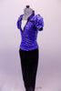 Two-piece costume has a periwinkle sequined velvet top with black trimmed lapelled collar, pouffe sleeves and white center inlay. The black trim is complemented by black velvet straight leg pants and a bowler hat. Left side no hat.