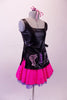Hairdresser themed costume has black leatherette tunic style top with hand painted scissors, comb and blow drier. The tunic top ties at the sides and sits over top of a bright pink skirt with purple tricot petticoat. Comes with pink hairbow. Right side