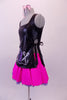 Hairdresser themed costume has black leatherette tunic style top with hand painted scissors, comb and blow drier. The tunic top ties at the sides and sits over top of a bright pink skirt with purple tricot petticoat. Comes with pink hairbow. Left side
