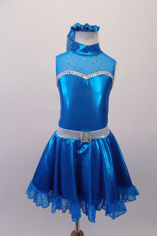 Shimmery turquoise blue crystal lined sweetheart bust dress has silver edging, sheer sparkle upper with a high collar. Back clips at neck with large keyhole opening. The skirt has sheer sparkle ruffle and petticoat with crystal buckle accented silver waistband. Comes with matching hair accessory. Front