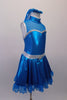 Shimmery turquoise blue crystal lined sweetheart bust dress has silver edging, sheer sparkle upper with a high collar. Back clips at neck with large keyhole opening. The skirt has sheer sparkle ruffle and petticoat with crystal buckle accented silver waistband. Comes with matching hair accessory. Right side