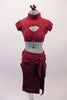 Modern russet coloured faux suede two-piece costume has knee length pencil skirt with, square panel front, large side slits & with a wide hip sash. The matching shrug style half-top has high neck collar & cap sleeves resting on a bra top. The back has bra closure & open keyhole back. Comes with a hair accessory. Front