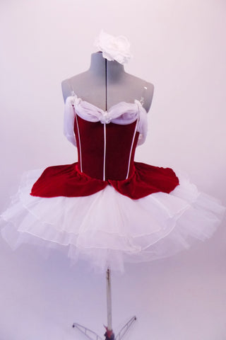 Gorgeous red velvet tutu has a red leotard base with white boning & princess cut. The neckline is draped with white chiffon that joins at the center of the back.  The skirt is comprised of a white tulle pull-on tutu with chiffon & red velvet overlay. Comes with white floral hair accessory & clear straps. Front