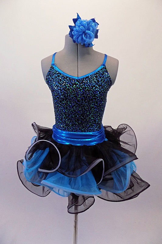 Glittery blue-green sequins cover the black base of this metallic blue banded leotard. The back is a low open scallop with blue star-shaped criss-cross straps. The matching pull-on skirt is layers of black and blue curly ruffle with a metallic blue waistband. Comes with matching hair accessory. Front