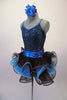 Glittery blue-green sequins cover the black base of this metallic blue banded leotard. The back is a low open scallop with blue star-shaped criss-cross straps. The matching pull-on skirt is layers of black and blue curly ruffle with a metallic blue waistband. Comes with matching hair accessory. Side