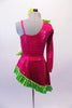 Two-piece costume has fuchsia rectangle sequined one sleeved shrug with a lime green ruffle that exposes a black lace covered fuchsia leotard with 3-D floral applique. The matching angled pull-on skirt is fuchsia sequined with green ruffle. Comes with a green floral hair accessory. Back