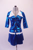 An airline themed two-piece costume is a metallic turquoise blazer with wide double white lapel collar and waistband with brass buttons. The matching pull-on skirt has side slits. Front