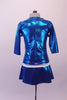 An airline themed two-piece costume is a metallic turquoise blazer with wide double white lapel collar and waistband with brass buttons. The matching pull-on skirt has side slits. Back