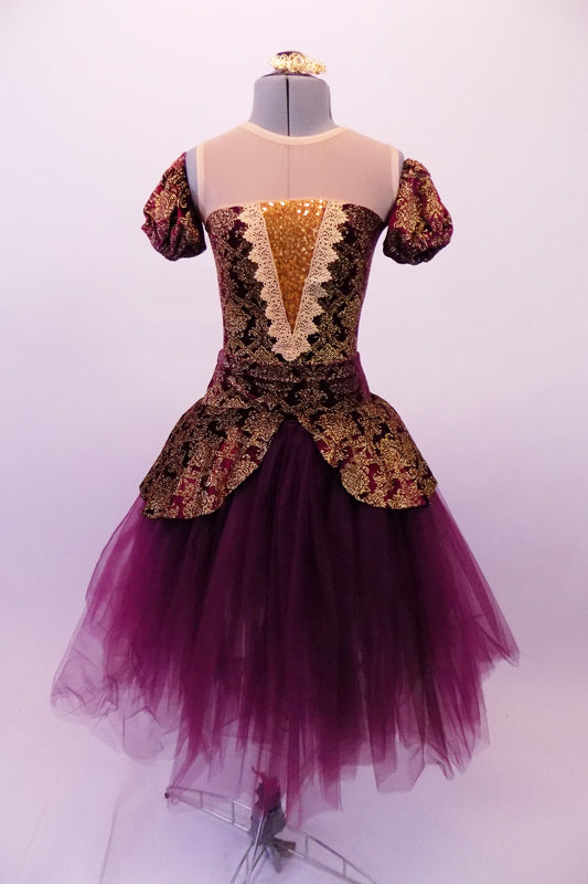 Stunning baroque style ballet dress is a burgundy base with gold brocade print & sheer nude illusion neckline above inlay pop. The matching pull-on peplum overlay with a wide waistband sits over top of a burgundy tulle romantic tutu skirt. The low scoop back and separate pull-on pouffe sleeves finish the look. Front